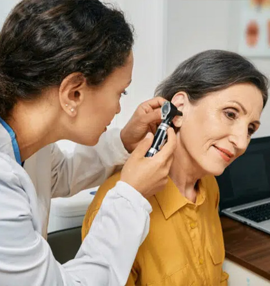 A doctor examiningg a patient's ear.